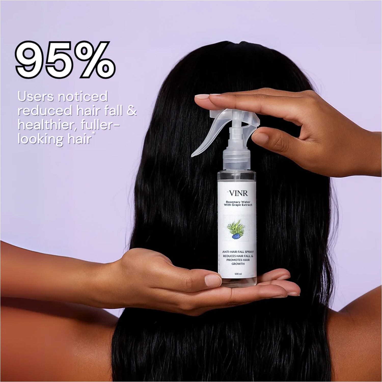 Woman holdinga  bottle of rosemary water hairspray
